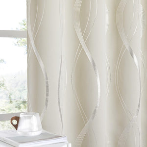 Cream opaque curtains with shimmering silver wavy lines, seen by a sunlit window.