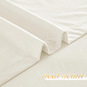 Soft cream-colored faux velvet curtain fabric showing a meticulously neat seam and elegant folds.