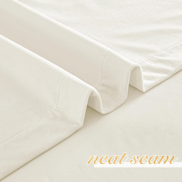 Soft cream-colored faux velvet curtain fabric showing a meticulously neat seam and elegant folds.