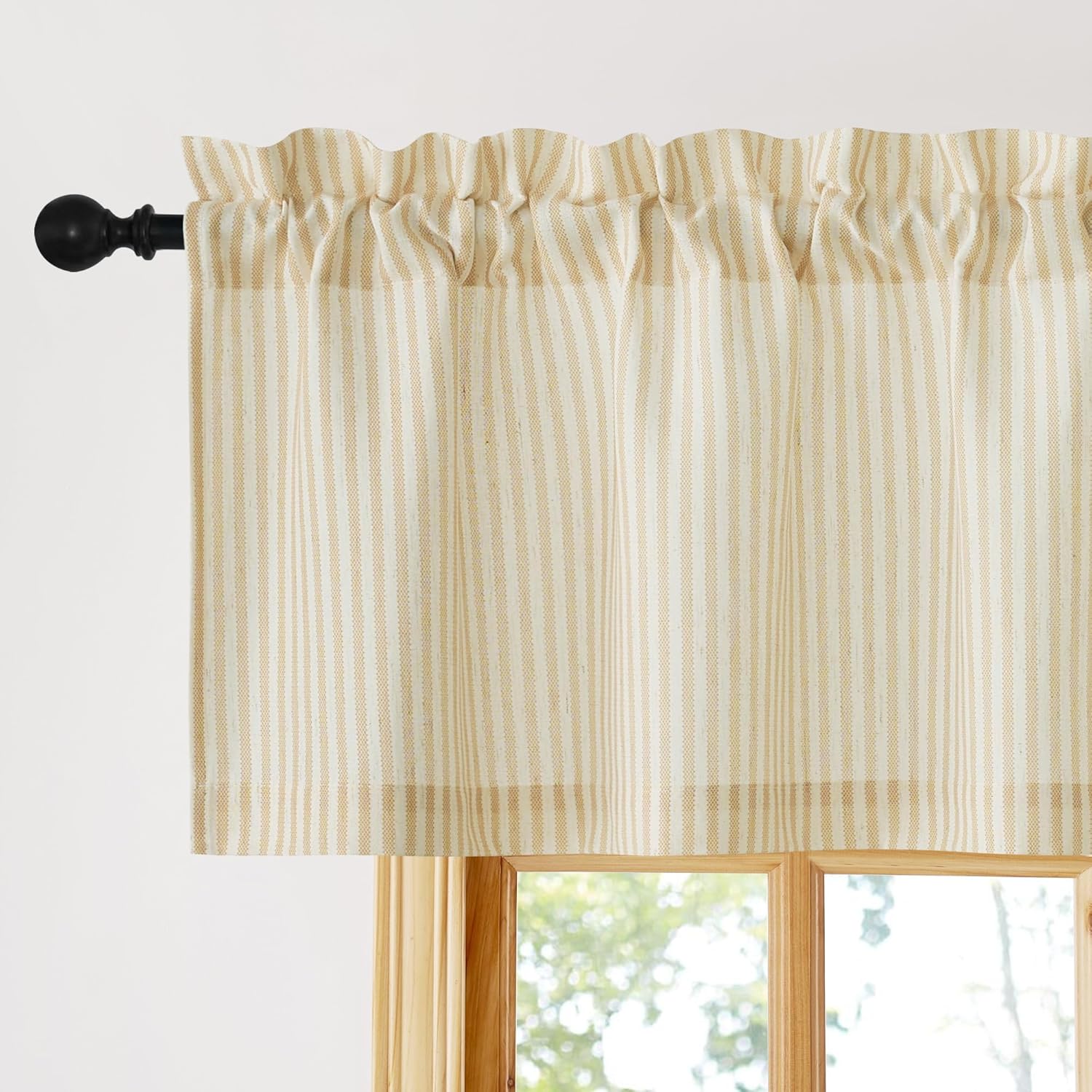 Cream and tan striped rod pocket valance, gathered on a black curtain rod over a wooden window.