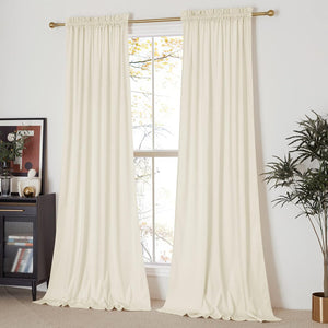 Elegant cream velvet rod pocket curtains hanging on a brass rod over a bright window, pooling on the floor.