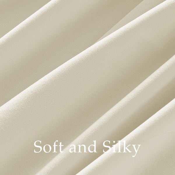 Close-up of luxurious creamy beige fabric showcasing its soft, silky smooth texture and graceful folds.
