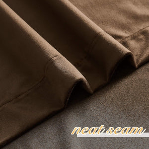 Close-up of dark brown textured blackout curtain fabric, highlighting a neatly stitched seam.