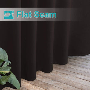 Close-up of dark brown blackout curtains with flat seam construction, neatly draped to a light wooden floor.