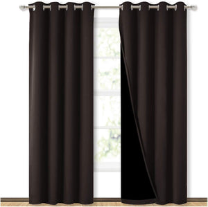 Dark brown blackout curtains with silver grommet tops, one panel pulled back showing the dark lining.