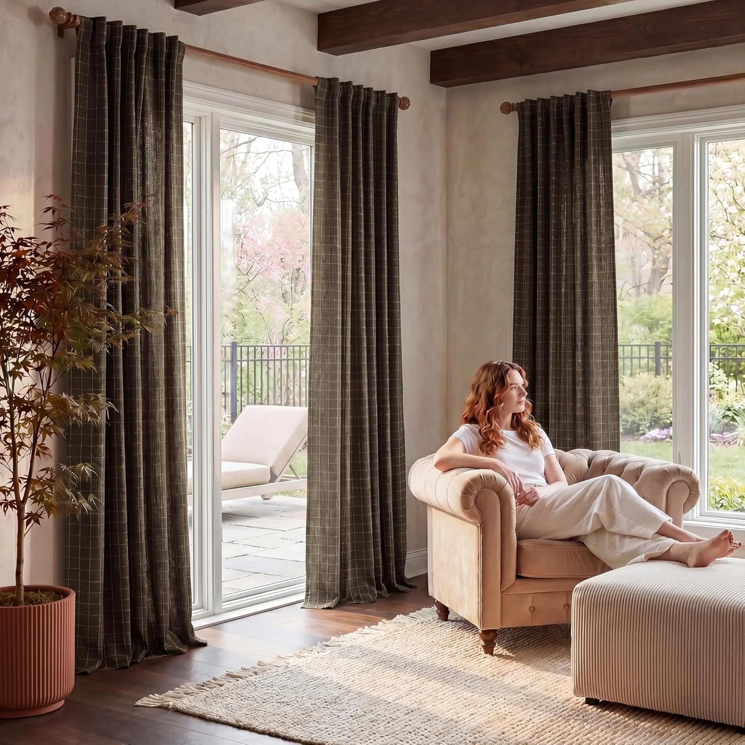 Dark brown checked textured curtains in a bright living room with a woman relaxing.