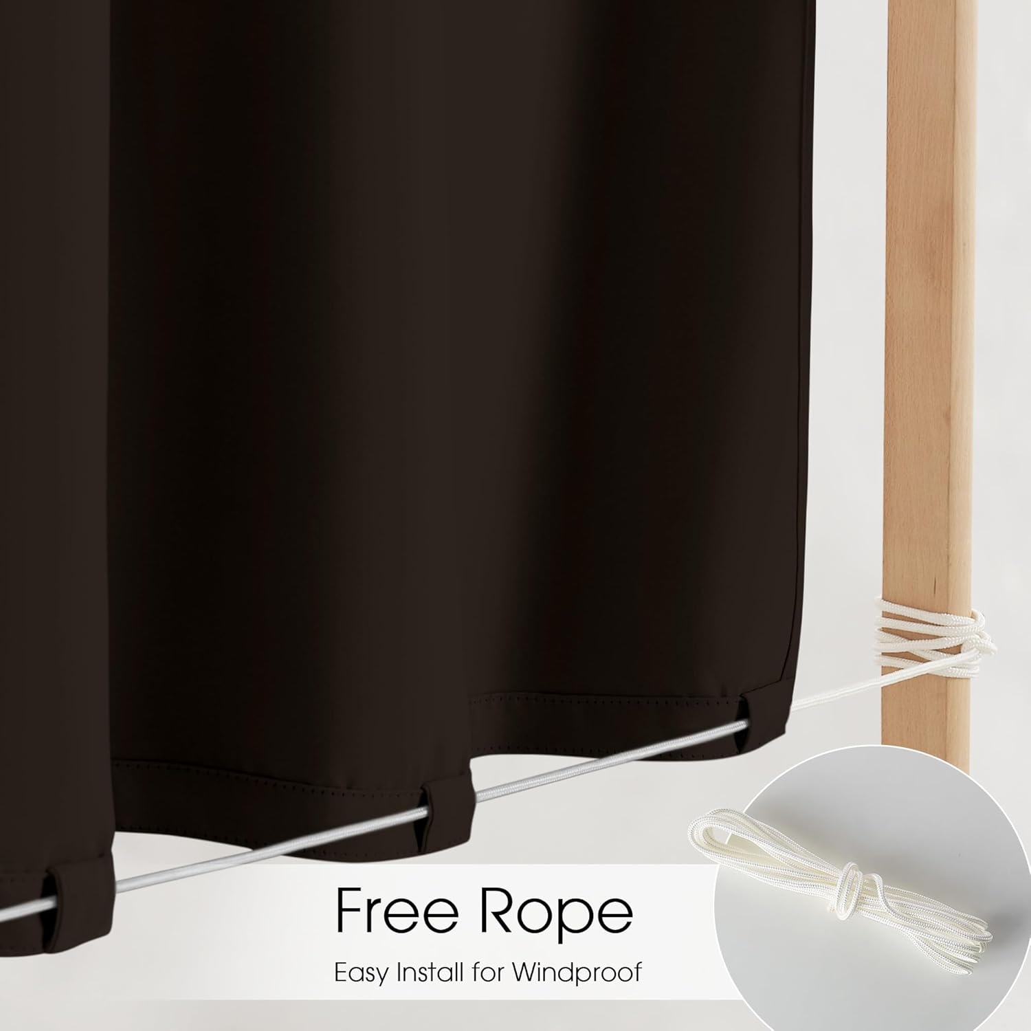 Dark brown outdoor curtain, bottom loops with white rope secured to wood post, windproof.
