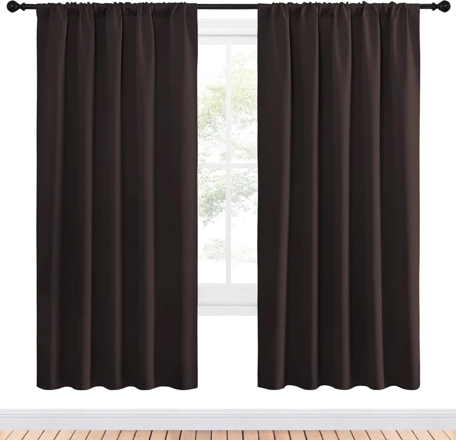 Dark brown blackout curtains with a rod pocket top hanging on a black rod in front of a white window.