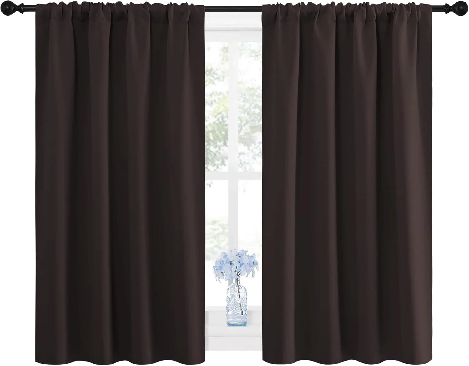 Dark brown rod pocket curtain panels on a black rod, with light blue flowers on a windowsill.