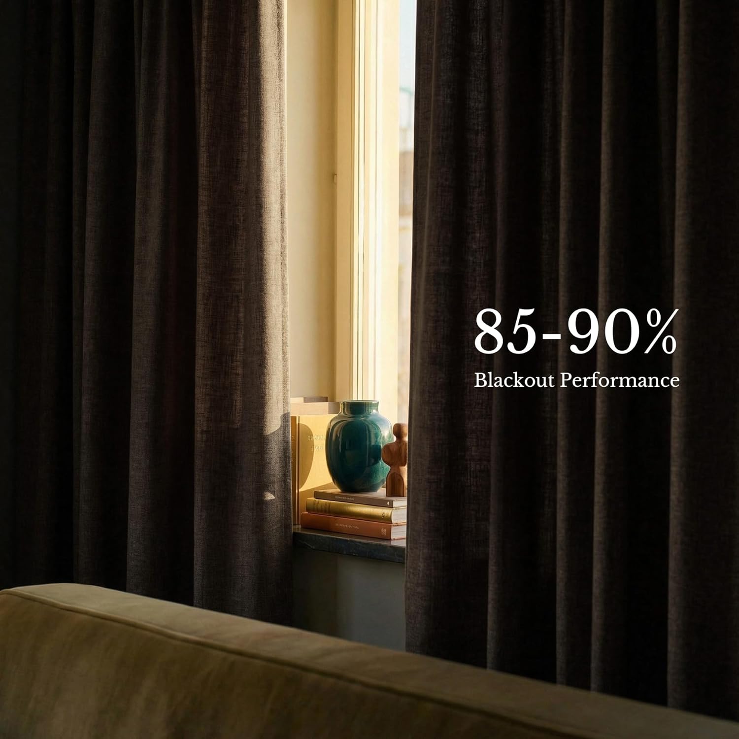 Dark brown textured blackout curtains hanging in a window, demonstrating 85-90% light blocking performance.