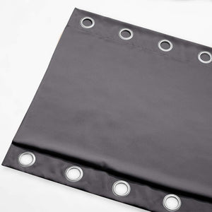 Dark gray blackout curtain panel featuring silver grommets along the top edge, made from a smooth, thick fabric.