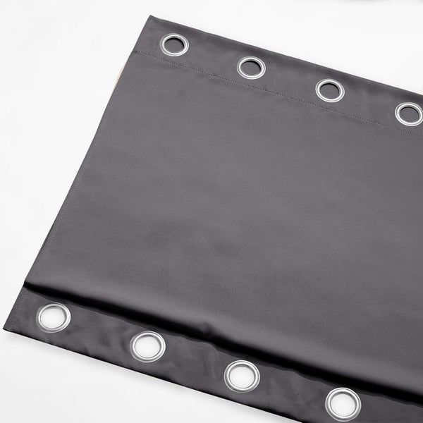 Dark gray blackout curtain panel featuring silver grommets along the top edge, made from a smooth, thick fabric.