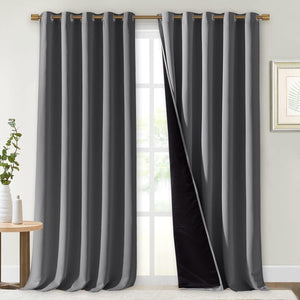 Dark gray blackout grommet curtains hung on a gold rod. One panel reveals black thermal lining.