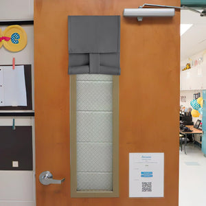 Dark gray fabric privacy shade covers rectangular window on wooden door, rolled up at bottom.