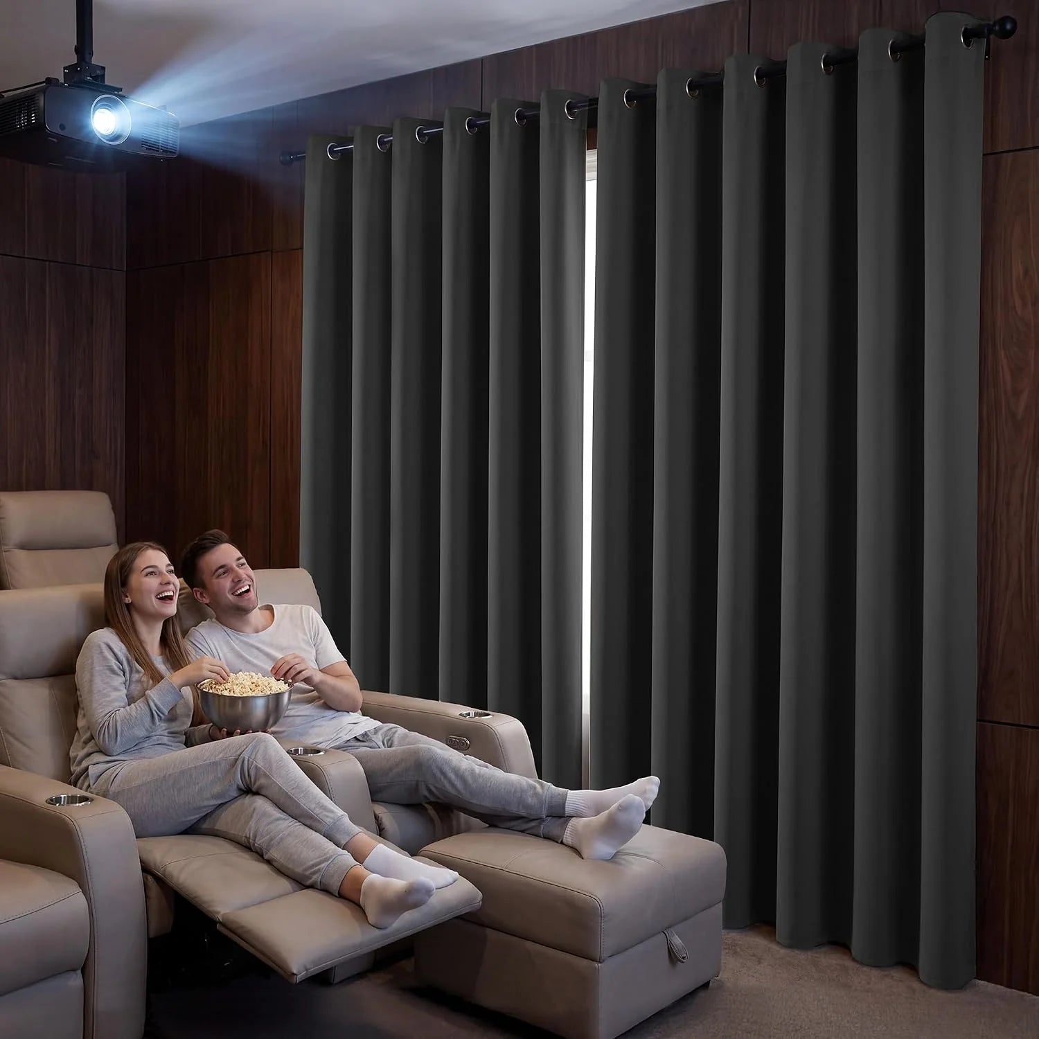 Dark gray grommet blackout curtains in home theater with couple watching movie