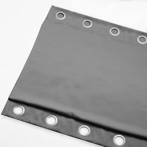 Close-up of a dark gray curtain panel with numerous silver grommets along the top and bottom edge.