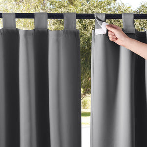 Dark gray outdoor curtains feature hook-and-loop tab tops; a hand demonstrates the easy closure.