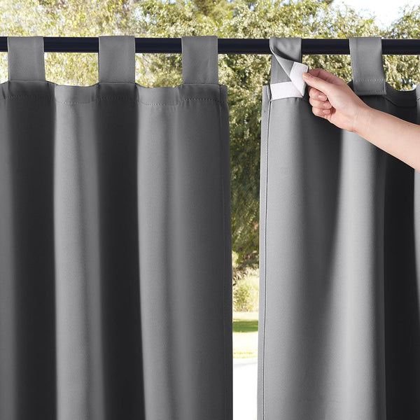 Dark gray outdoor curtains feature hook-and-loop tab tops; a hand demonstrates the easy closure.