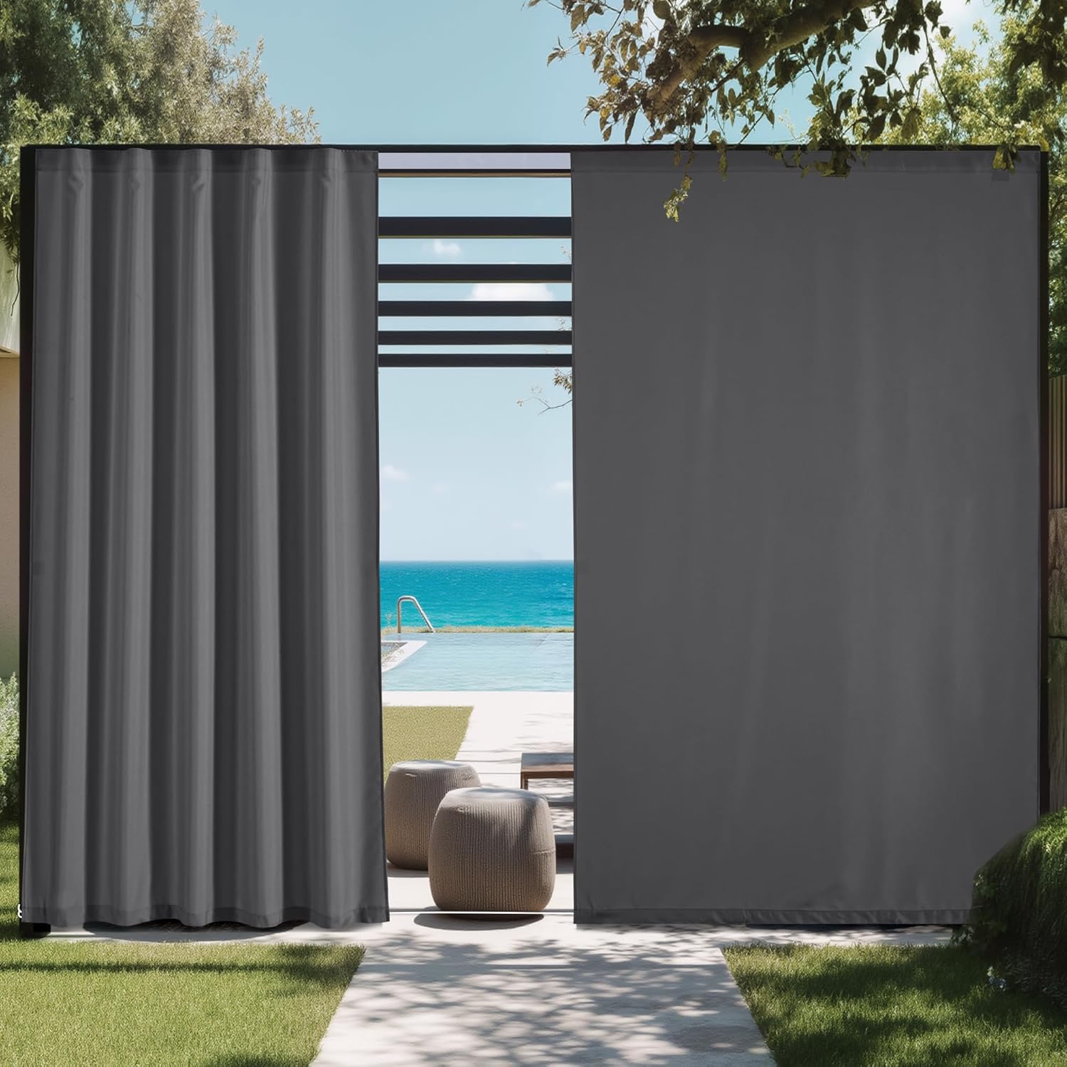 Dark gray outdoor privacy curtains on a modern pergola, one drawn back, one extended, next to a pool with ocean view.