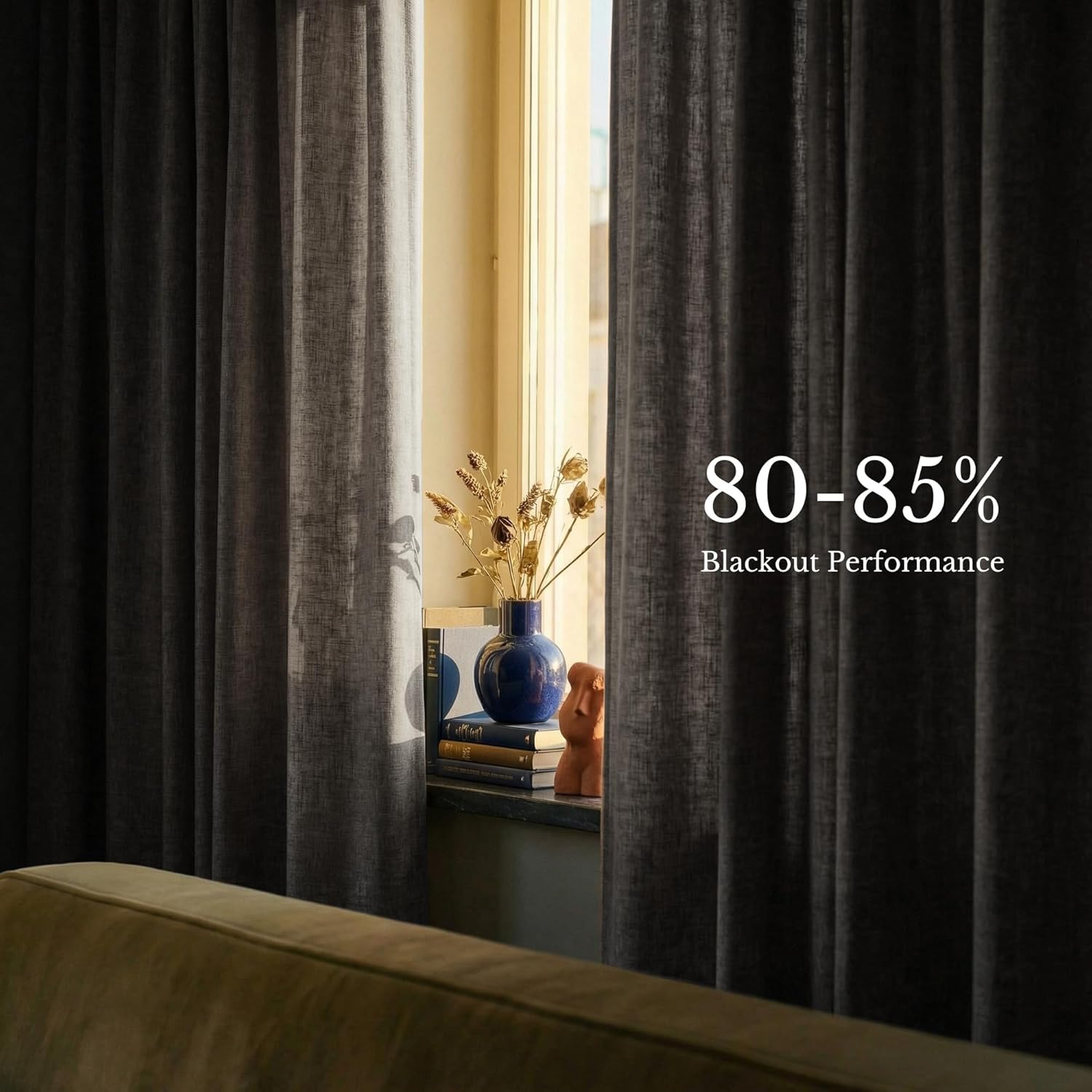 Dark gray textured blackout curtains, partially drawn, effectively blocking sunlight from a window.