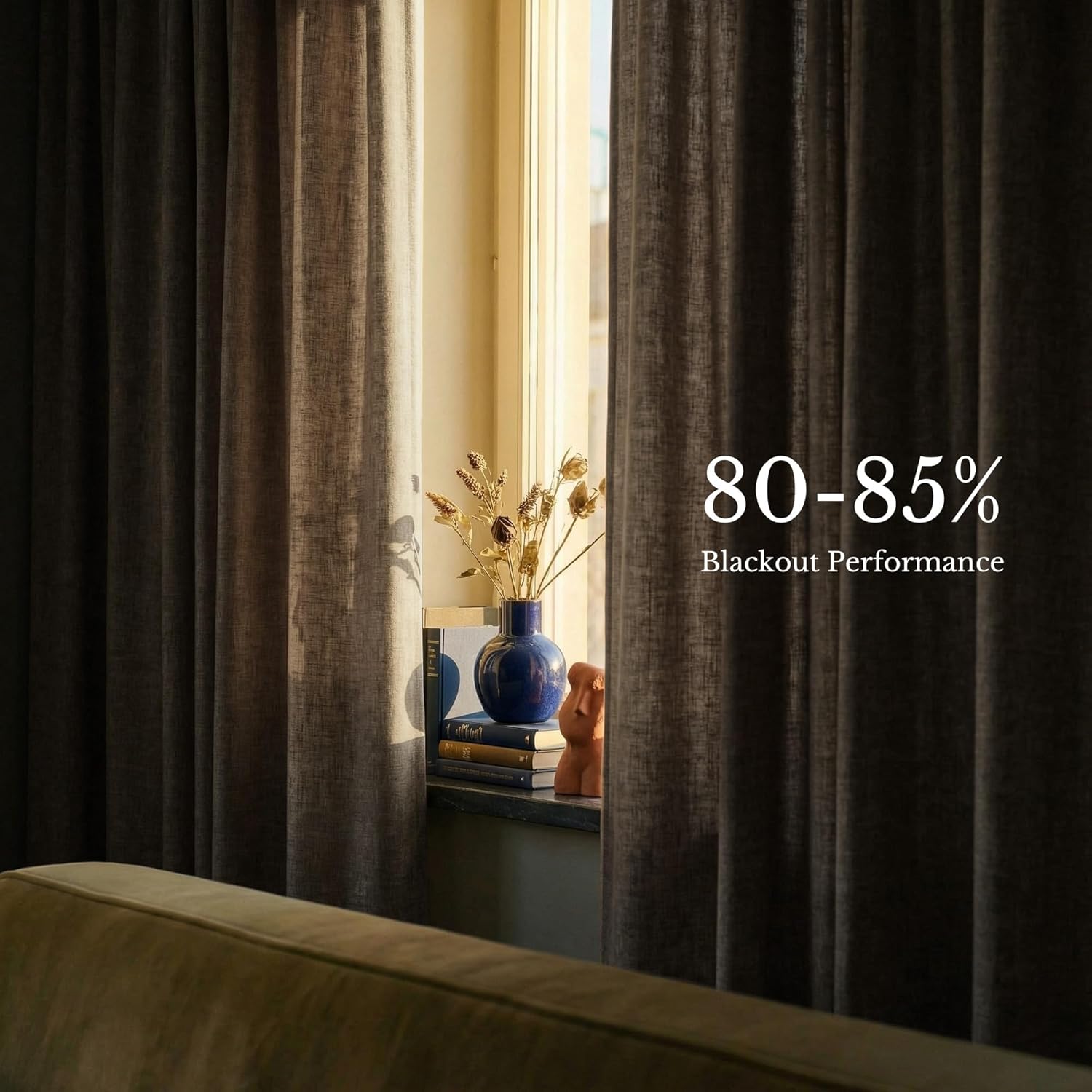 Textured dark gray blackout curtains offering 80-85% light blocking. Visible window with vase and books.