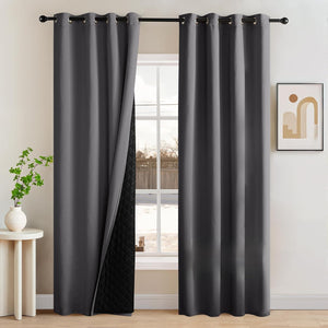 Pair of dark gray blackout curtains with silver grommets, revealing a thick quilted thermal lining.