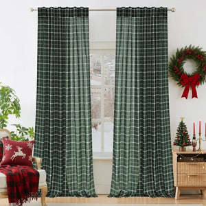 Pair of dark green and white plaid curtains hanging on a silver rod, enhancing a room decorated for Christmas.