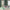Dark green plaid light filtering curtains with white grid pattern hanging in a living room.