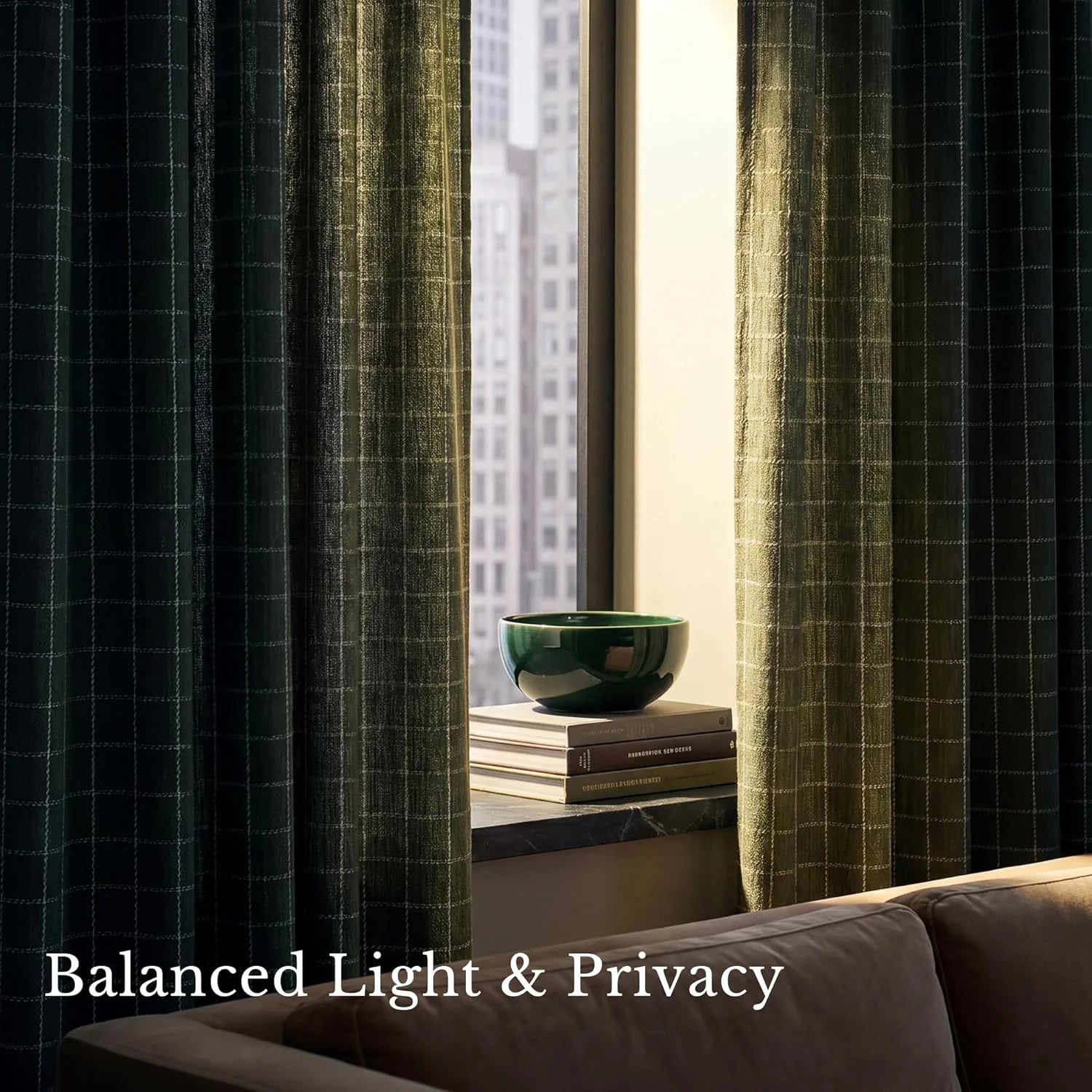 Dark green plaid linen curtains partially open in a modern urban room, revealing books and a city view.
