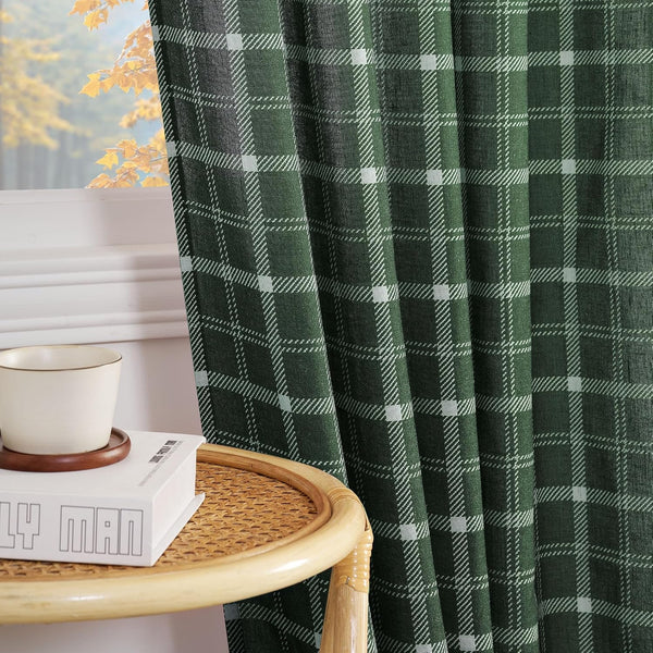 Dark green plaid window curtain with white check pattern. Visible with autumn trees outside a window.