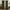 Dark green textured pinch pleat curtains hanging on a wooden rod in a modern living room
