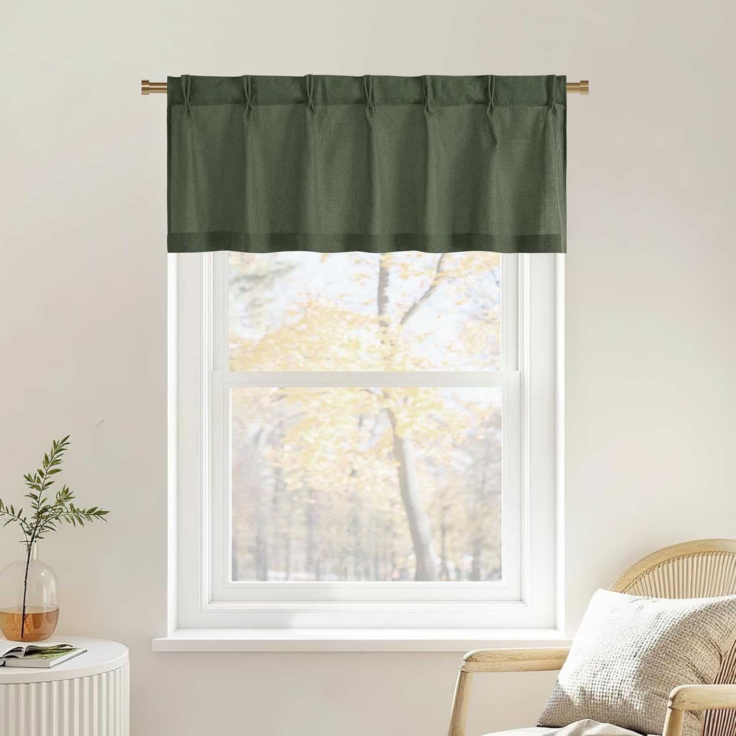 Dark green textured window valance with top tabs hanging on a golden rod over a bright window.