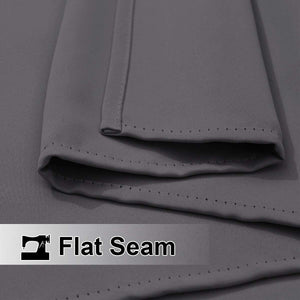 Close-up shows dark grey room darkening curtain fabric, highlighting the precise flat seam construction with visible stitching.