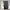 Dark grey blackout grommet curtain panel hanging on a window with a metal rod, revealing its black lining.
