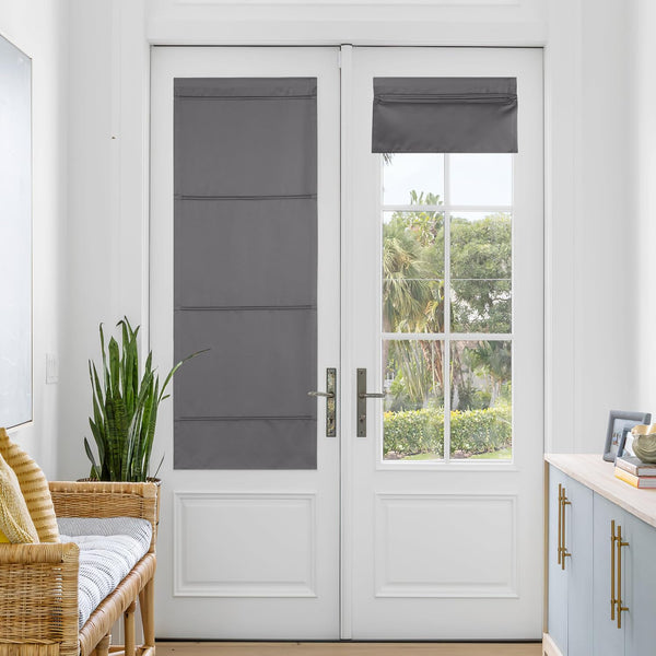 Dark grey fabric roman shades on white French doors. One fully extended, one partially rolled up.