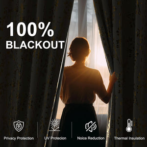 Woman pulling back dark grey blackout curtain with gold floral pattern, demonstrating light blocking.