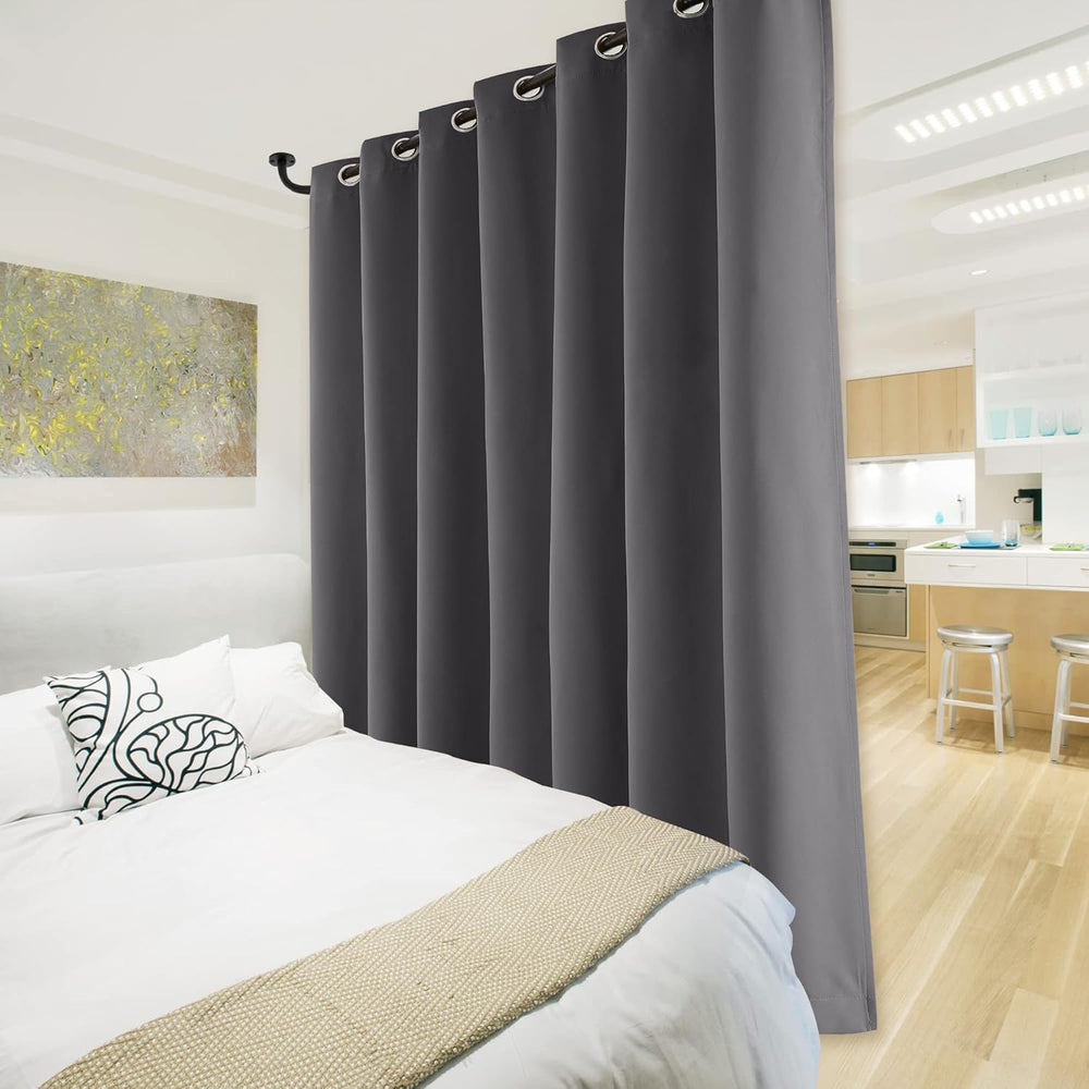 Dark grey blackout grommet curtain panel hanging on a window with a metal rod, revealing its black lining.