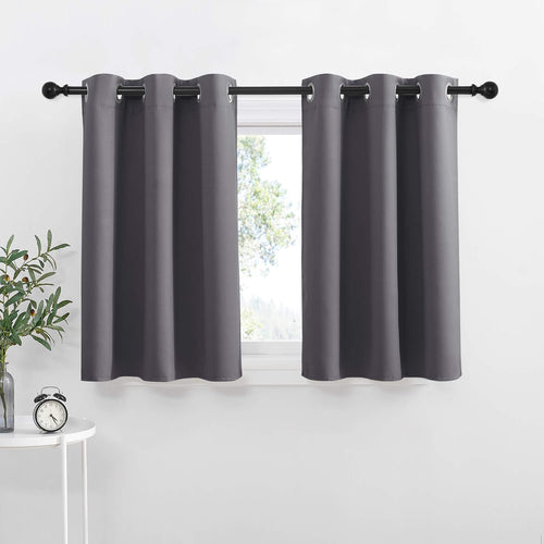 Pair of dark grey grommet top tier curtains on a black rod, partially covering a window.