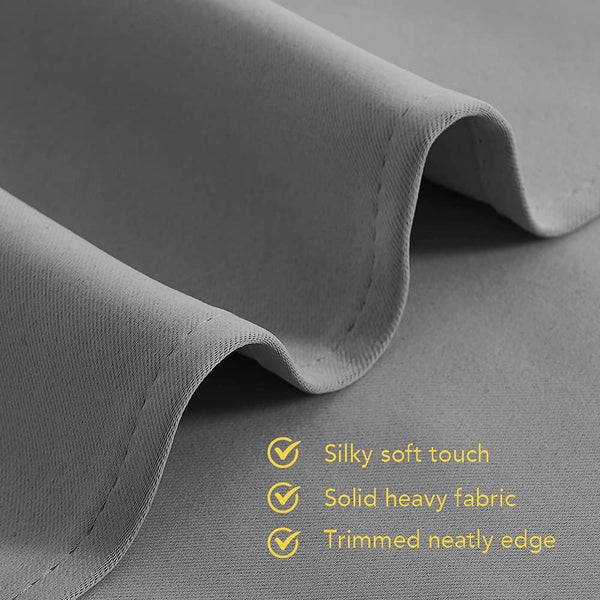 Close-up of dark grey, silky soft, solid heavy curtain fabric with a neatly trimmed edge.
