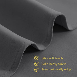 Close-up of dark grey fabric, highlighting silky soft touch, solid heavy weave, and neatly trimmed edge.