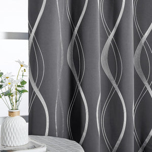 Dark grey blackout curtain with shimmering silver wavy line pattern by a window.