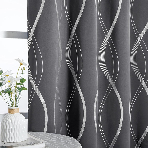 Dark grey blackout curtain with shimmering silver wavy line pattern by a window.