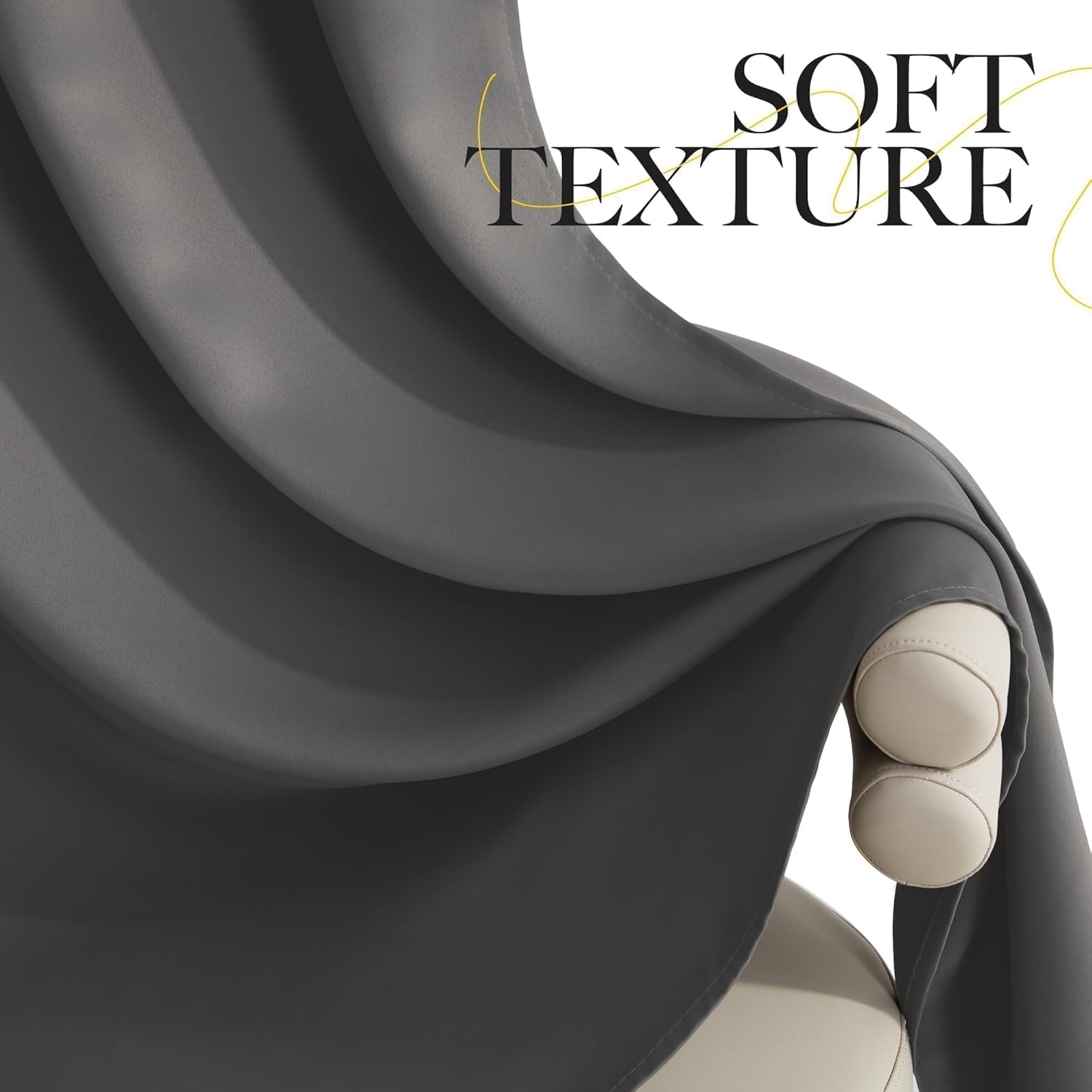 Close-up of a dark grey, soft texture curtain fabric with elegant folds, draped over a light beige surface.