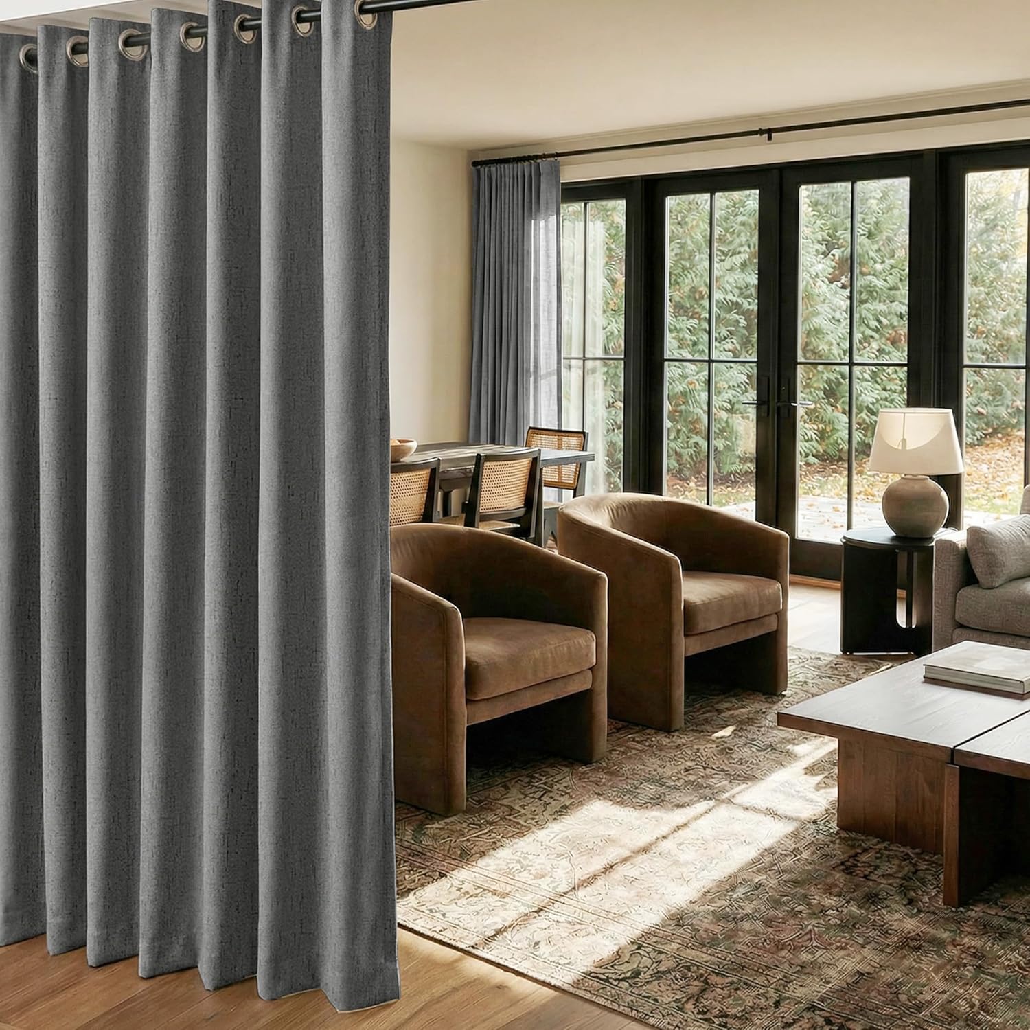Dark grey textured grommet top curtain panel dividing a modern living room from dining area.