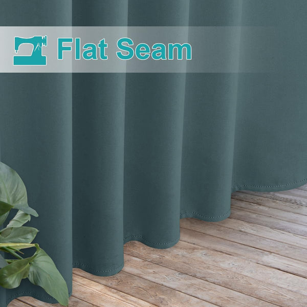 Deep teal blackout curtain drapes on wooden floor, showcasing its flat seam construction and neatly stitched hem.
