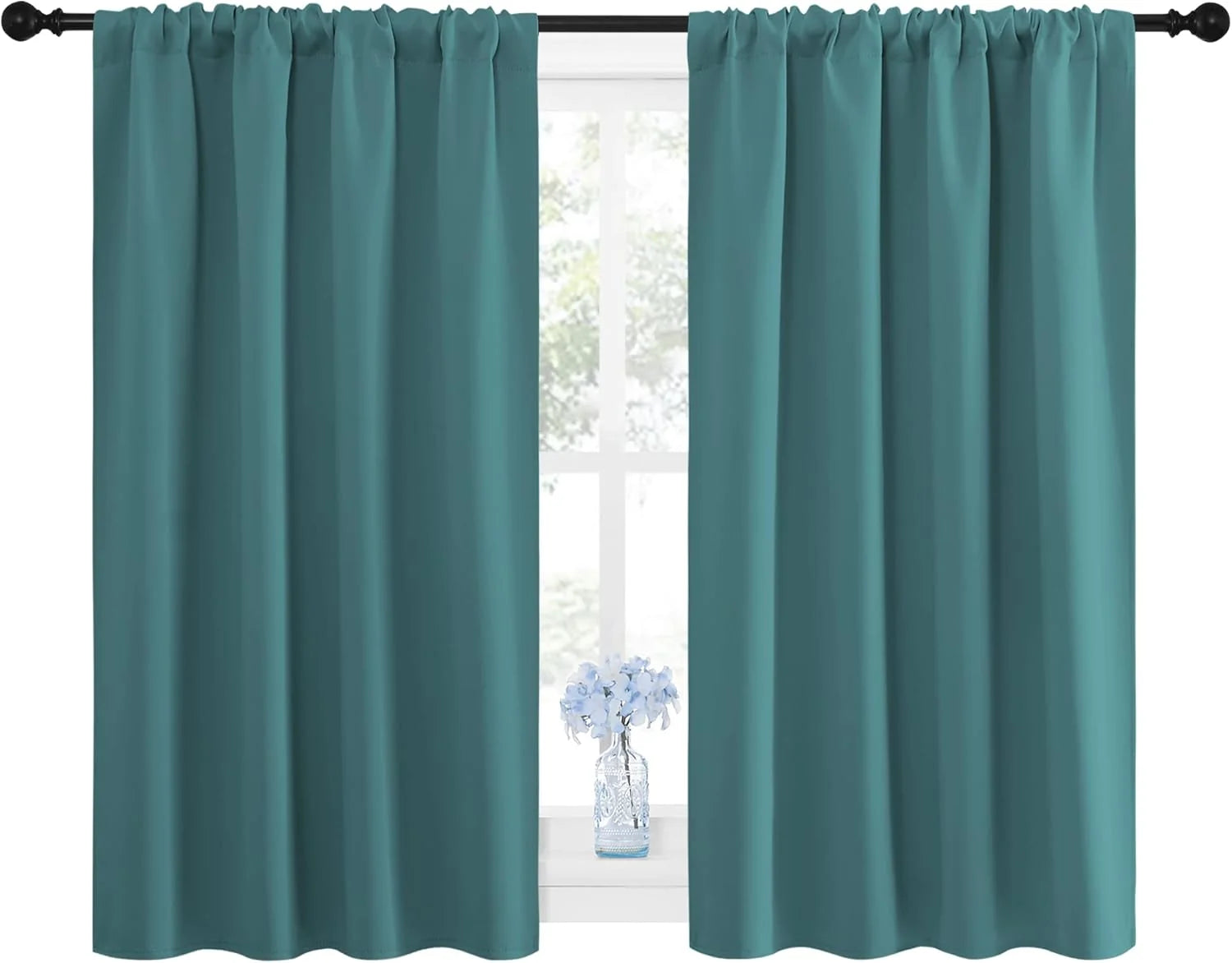 Pair of dark teal blackout curtains with rod pocket top on black rod