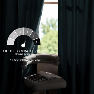 Dark teal velvet blackout curtains drawn across a window, effectively blocking light. A modern chair with a book is visible.