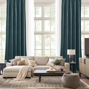 Dark teal velvet pleated curtains hanging in a modern living room, offering a room darkening effect.