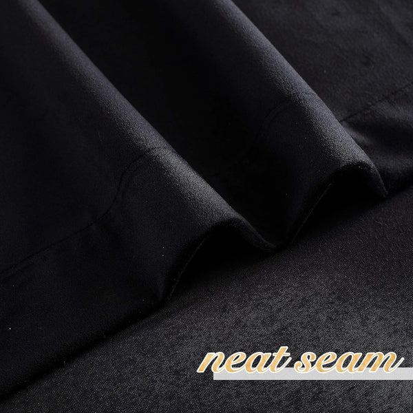 Close-up of deep black finely woven blackout curtain fabric, showcasing a neat seam detail.