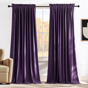Deep purple velvet curtains with a gathered rod pocket top, hanging from a black rod in a cozy room.
